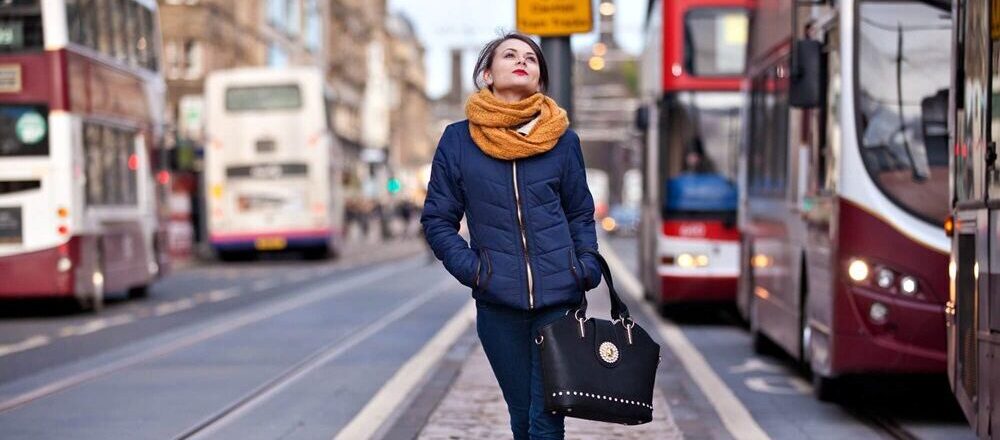 Female walking alone through busy Edinburgh street