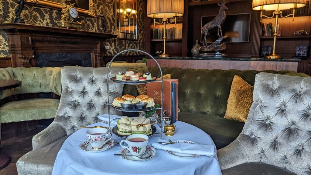 An afternoon tea setup on a round table with the bonham library in the background