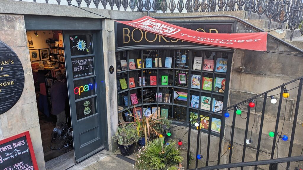 the stairs down to a bookshop in edinburgh, with a curved window full of books