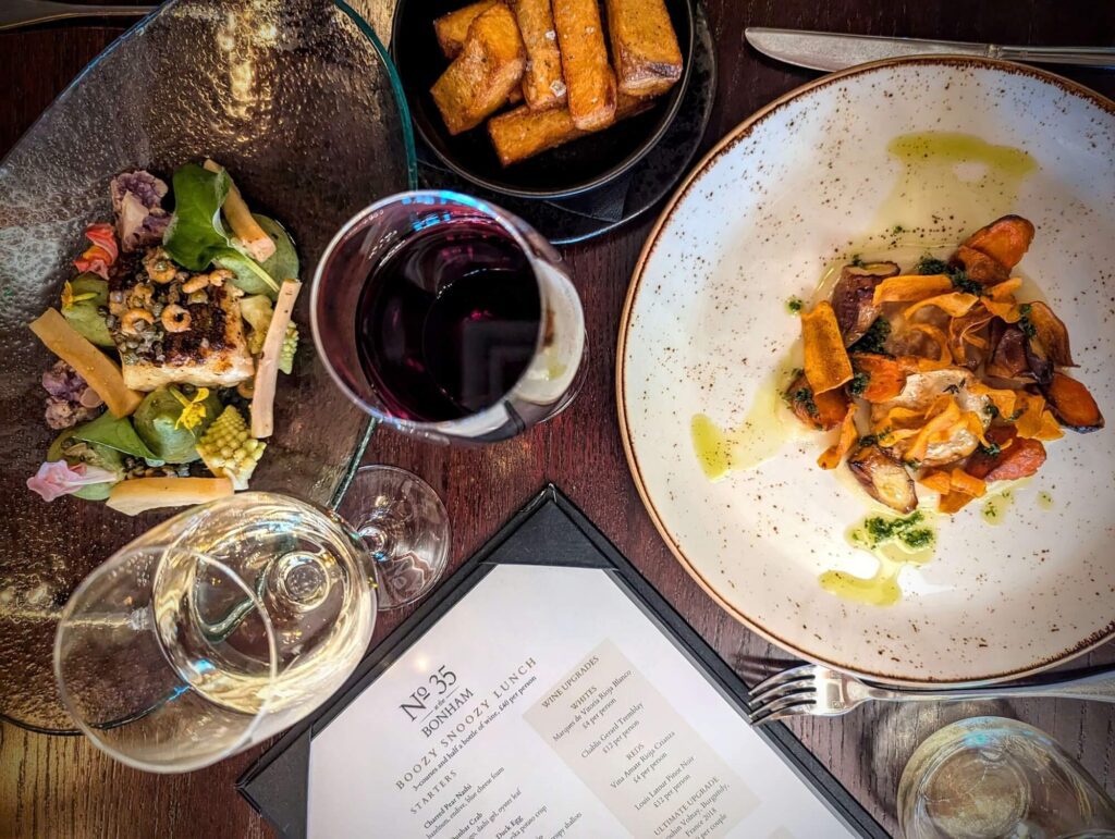 flat lay table with the bonham's boozy snoozy lunch plates and wine