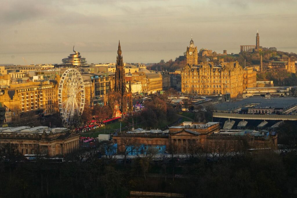 edinburgh christmas market in the daytime with the sun setting across the east