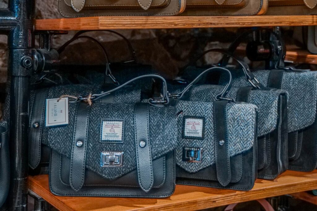grey harris tweed satchel bags on a shelf in islander uk shop in edinburgh