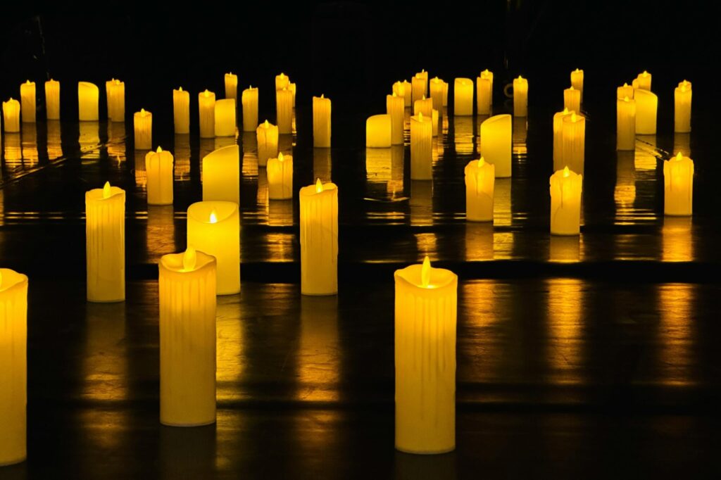 candles laid out across a floor in the dark