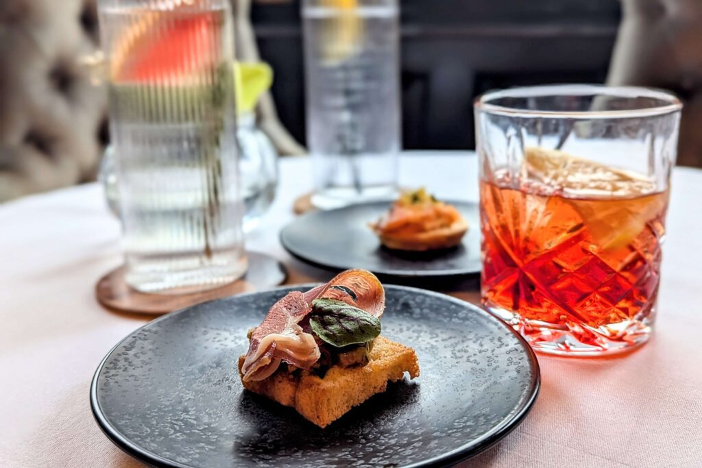 a small canape with 3 cocktails in the background