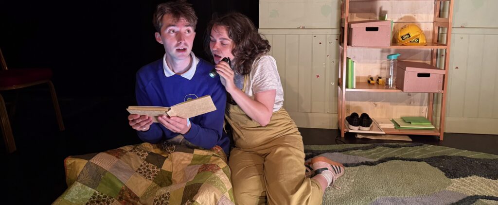 a man and a woman reading a book on stage with a flashlight the truth about trees edinburgh fringe show