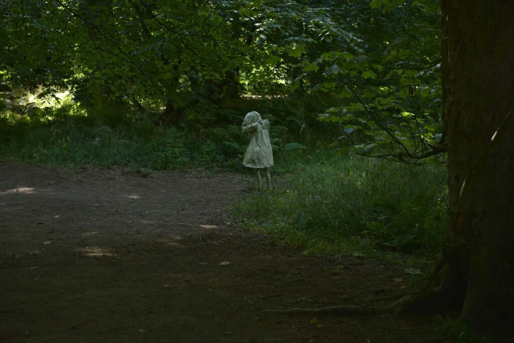 life sized statue of a little girl in the woods at jupiter artland